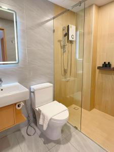 a bathroom with a shower and a toilet and a sink at Wynora Hotel in Klong Toi +35 photos