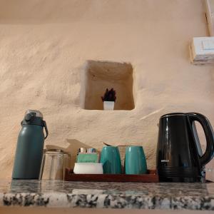 a counter top with cups and utensils on a shelf at Buransh Stays - Sari in Sari