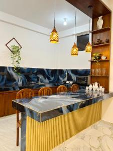 a kitchen with a bar with chairs and lights at Blessora Sky Retreat in Kalutara
