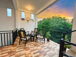 a porch with a table and chairs on a balcony at Blessora Sky Retreat in Kalutara