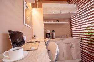 eine Küche mit einem Schreibtisch, auf dem ein Laptop und eine Tasse Kaffee stehen in der Unterkunft Studio rent in Piura + 32 Fotos