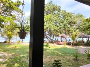 a view of the beach from a house window at Papua Risen Beach Front Bungallow in Insyurifuri