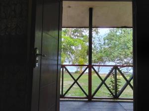 an open door with a view of a field at Papua Risen Beach Front Bungallow in Insyurifuri +2 photos