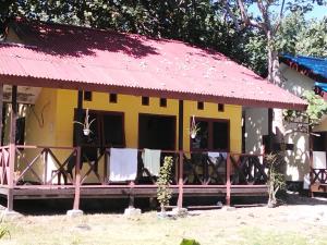 a small yellow house with a red roof at Papua Risen Beach Front Bungallow in Insyurifuri