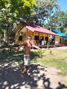 a man holding a frisbee in front of a house at Papua Risen Beach Front Bungallow in Insyurifuri