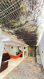 a living room with an orange hammock under a ceiling at Comfortable house in Natal in Natal