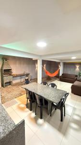 a dining room with a table and chairs and a couch at Comfortable house in Natal in Natal