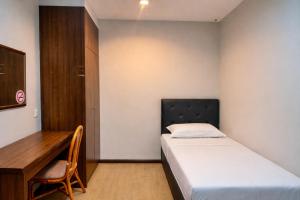a small bedroom with a bed and a desk at EL Zahraa Moda Hotel Alor Setar in Alor Setar