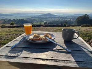 a plate of food on a table with a glass of orange juice at The Top Place Retreat in Caveside
