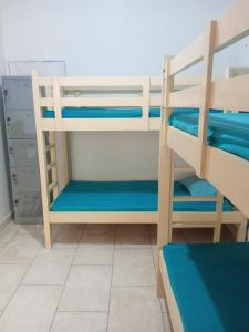 a room with two bunk beds with blue sheets at Dhika Adventure DPS in Denpasar