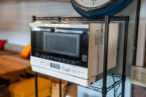 a microwave on a rack with a clock on top at Oceanfront Up to 14 Guests BBQ Available オーシャンフロント小浜田烏 in Obama
