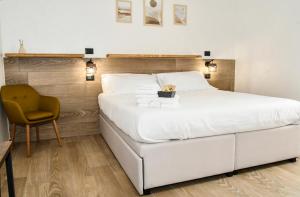 a bedroom with a large white bed and a chair at Hasu Rental Rooms in Trani