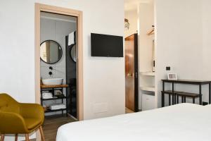a bedroom with a bed and a desk and a mirror at Hasu Rental Rooms in Trani