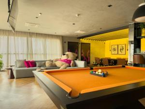 a living room with a pool table and a teddy bear at Sky Design Alphaville Hotel Residence in Barueri
