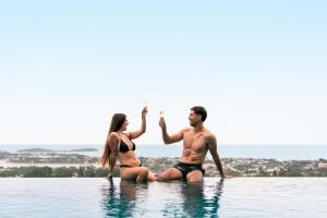 a man and woman sitting in the water with drinks at Savaya Samui Villa in Ban Ko Khwan