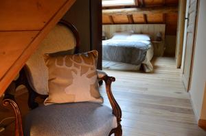 - Silla con almohada en una habitación con cama en chambres et table d'hôtes du Péré en Boussenac