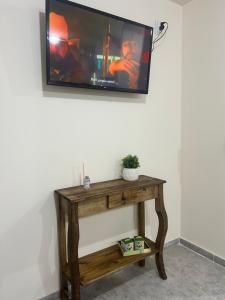 a flat screen tv on a wall with a wooden table at Cima Departamentos in Rivadavia
