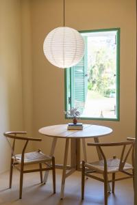 a dining room table with two chairs and a lamp at Oceanchild Khaolak in Khao Lak