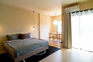 a bedroom with a bed and a dining room with a table at Oceanchild Khaolak in Khao Lak