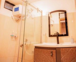 a bathroom with a shower and a sink and a mirror at Hill Safari - Tea Estate Villa in Ohiya
