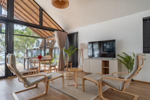 a living room with a table and chairs and a television at The Cosy Sunset Beach Resort in Thong Sala
