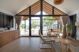 a kitchen and dining room with a large window at The Cosy Sunset Beach Resort in Thong Sala