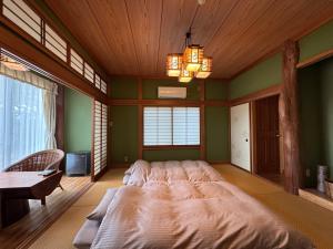 a large bed in a room with green walls at スピークイージー in Higashiizu