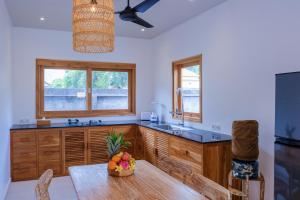 a kitchen with a sink and a table with a bowl of fruit at Villa Jati Private Pool - Amed in Amed
