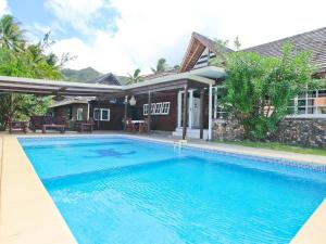 a swimming pool in front of a house at FARE MOOREA in Moorea
