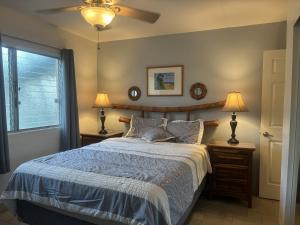a bedroom with a bed and two lamps and a window at Affordable Vacation Accommodations in Maui at the Kihei Kai Nani Resort in Kihei +38 photos