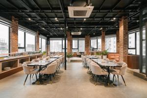 a restaurant with tables and chairs in a room with windows at San Hanoi Hotel & Gaming in Hanoi