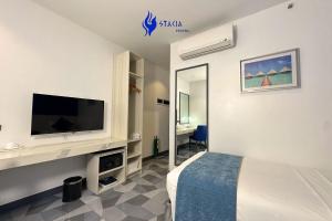 a bedroom with a bed and a tv on a wall at Stacia Hotel in Cebu City +15 photos
