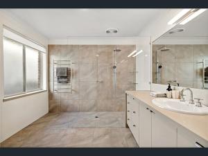 a bathroom with a shower and a sink and a mirror at The Waterville in Patterson Lakes +16 photos