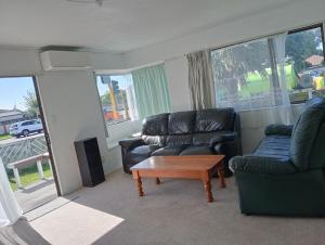a living room with two chairs and a coffee table at Papamoa budget accomodation's in Tauranga