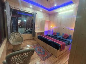 a bedroom with a bed and a window and a chair at Shiva cottage in Kullu Manali +8 photos
