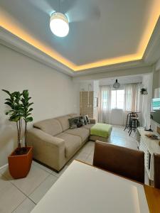 a living room with a couch and a table at Piscina, churrasqueira, garagem, sauna e academia! in Capão da Canoa