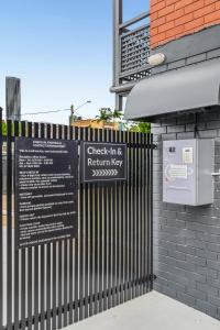 a sign on a fence next to a building at Spring Hill Inn in Brisbane