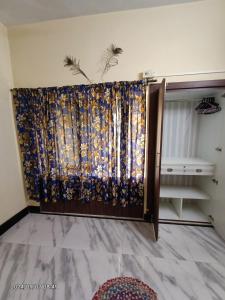 a sliding door with a curtain in a room at Cozy braket in kolkata