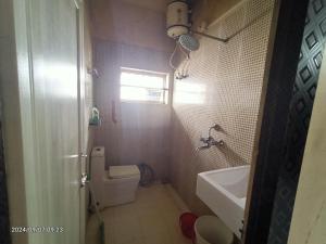 a bathroom with a toilet and a sink at Cozy braket in kolkata
