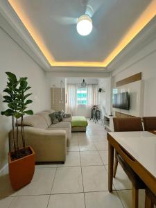 a living room with a couch and a table at Piscina, churrasqueira, garagem, sauna e academia! in Capão da Canoa