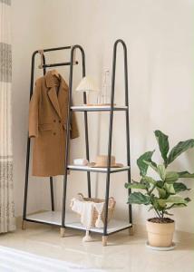 a metal shelf with a coat on it next to a plant at House Nguyễn in Da Lat