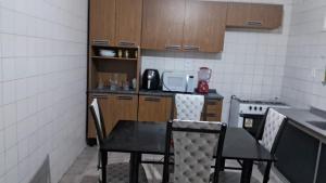 a small kitchen with a table and chairs in it at Casa Samambaia in Piranhas