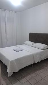 a bedroom with a large bed with white sheets and pillows at Casa Samambaia in Piranhas +4 photos