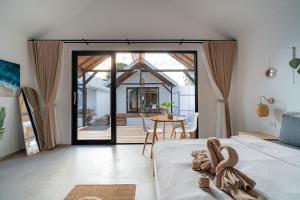 a bedroom with a bed and a sliding glass door at The Cosy Sunset Beach Resort in Thong Sala