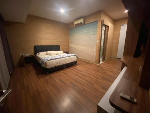 a bedroom with a bed and a wooden floor at Green Minimalist in Jakarta