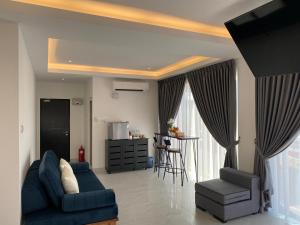 a living room with a blue couch and a chair at CS Junction Point - Special Day Room SDR in Kuala Pilah