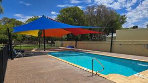 a colorful umbrella hanging over a swimming pool at Four Seasons Holiday Park in Marybrook