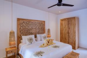 a bedroom with a large white bed with bananas on it at Villa Jati Private Pool - Amed in Amed +32 photos