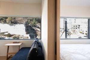 a bedroom with a bed and a large window at Trip made in Busan