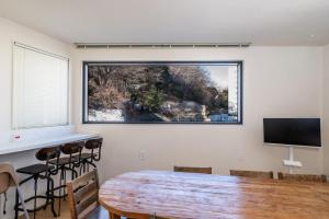 a dining room with a table and a large window at Trip made in Busan